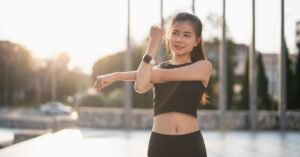 Woman wearing fitness tracker while exercising outdoors for weight loss